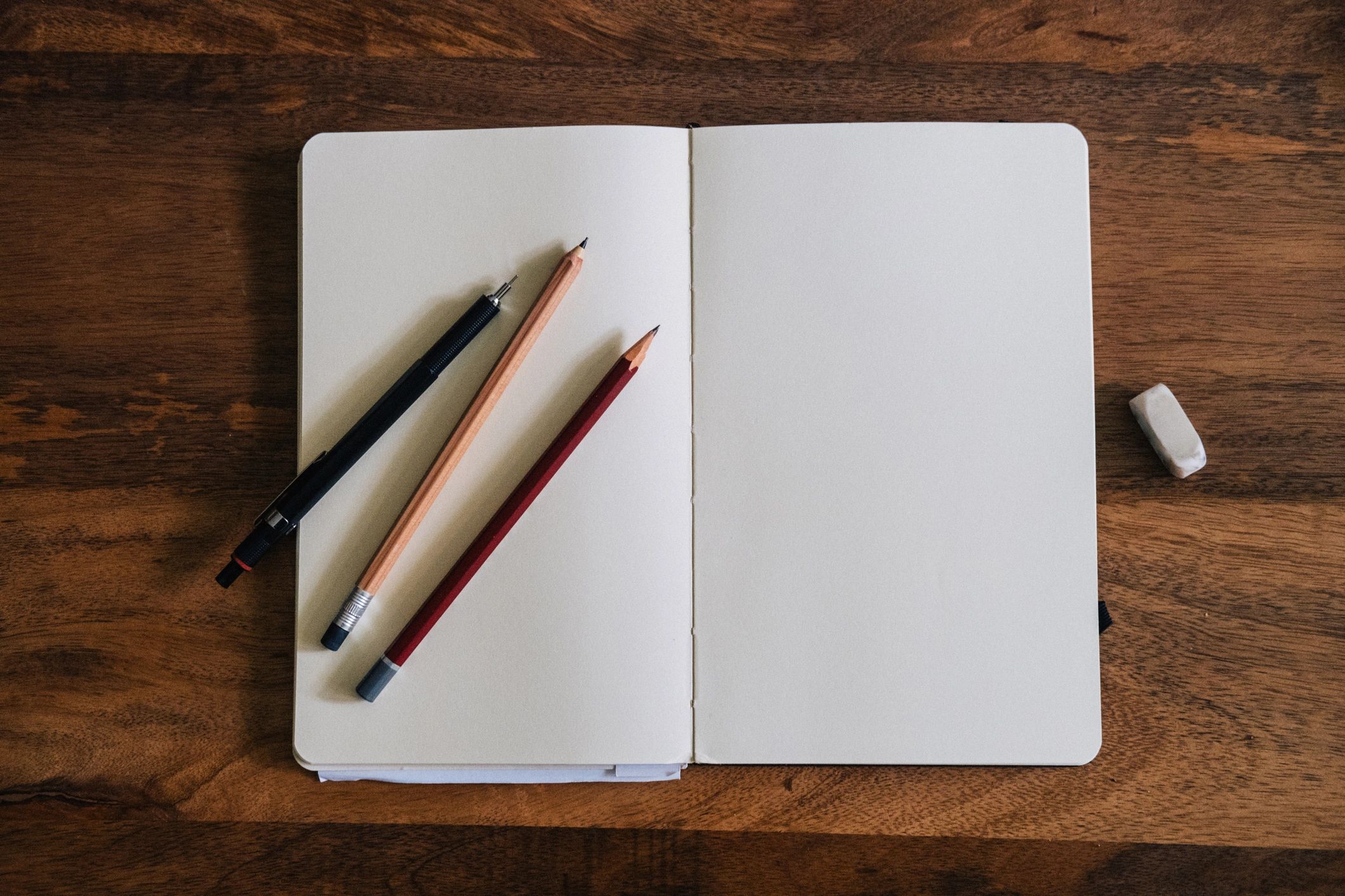Blank sketchbook on wooden table with crayons