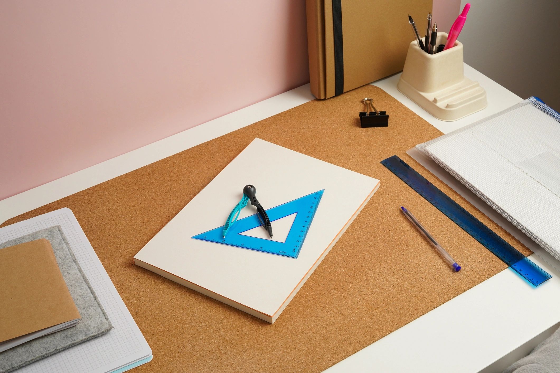 Geometry tools on a sketchbook at a modern desk